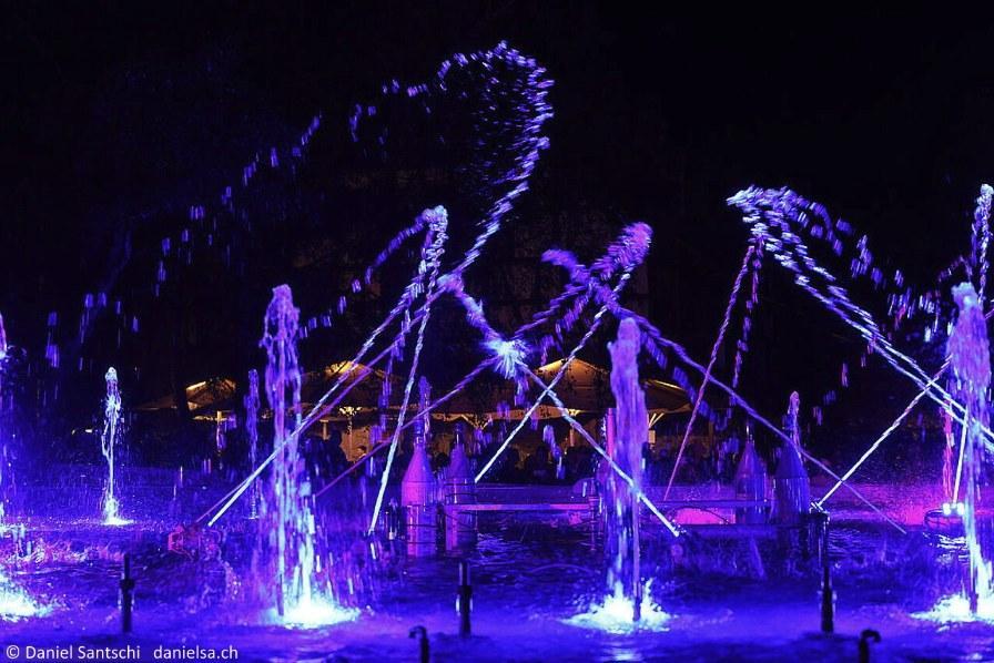 Violette Wasserbögen in der Nacht