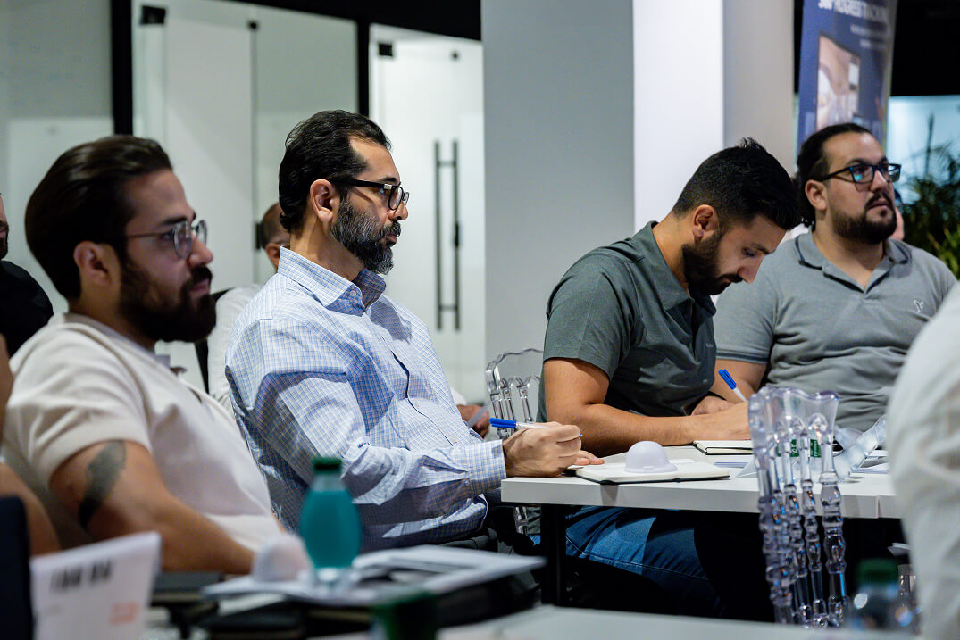 People sitting at a desk listening to a presentation