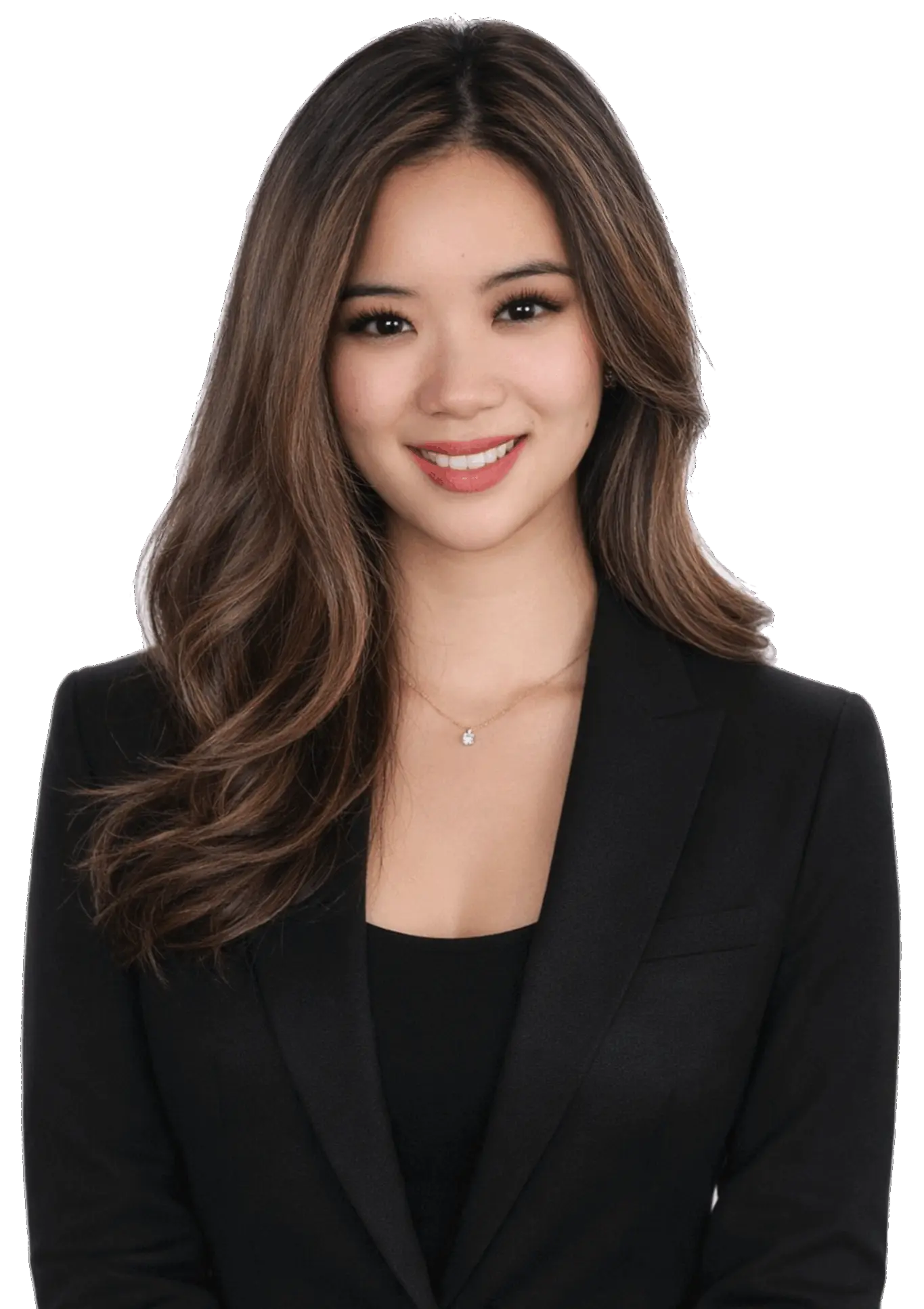Smiling young woman with long wavy hair wearing a black blazer and a necklace with a small pendant.