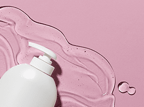 Man smiling while unpacking a small white box from a cardboard box in a warmly lit living room.