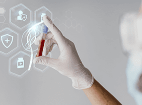 Man smiling while unpacking a small white box from a cardboard box in a warmly lit living room.