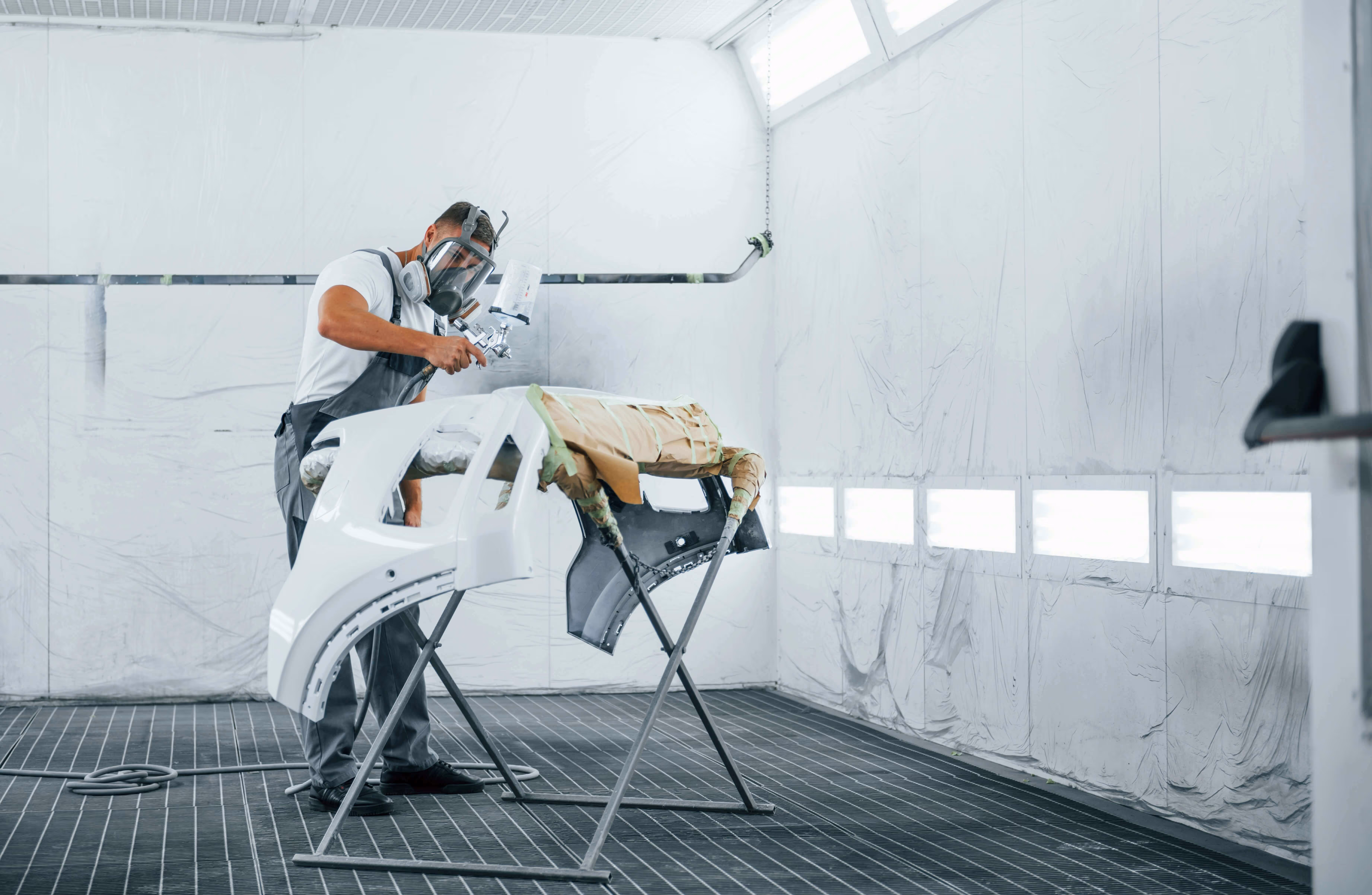 A car being professionally spray-painted in a bodyshop booth, highlighting Stellix Results' expert website design and SEO for vehicle body repair and accident centres.