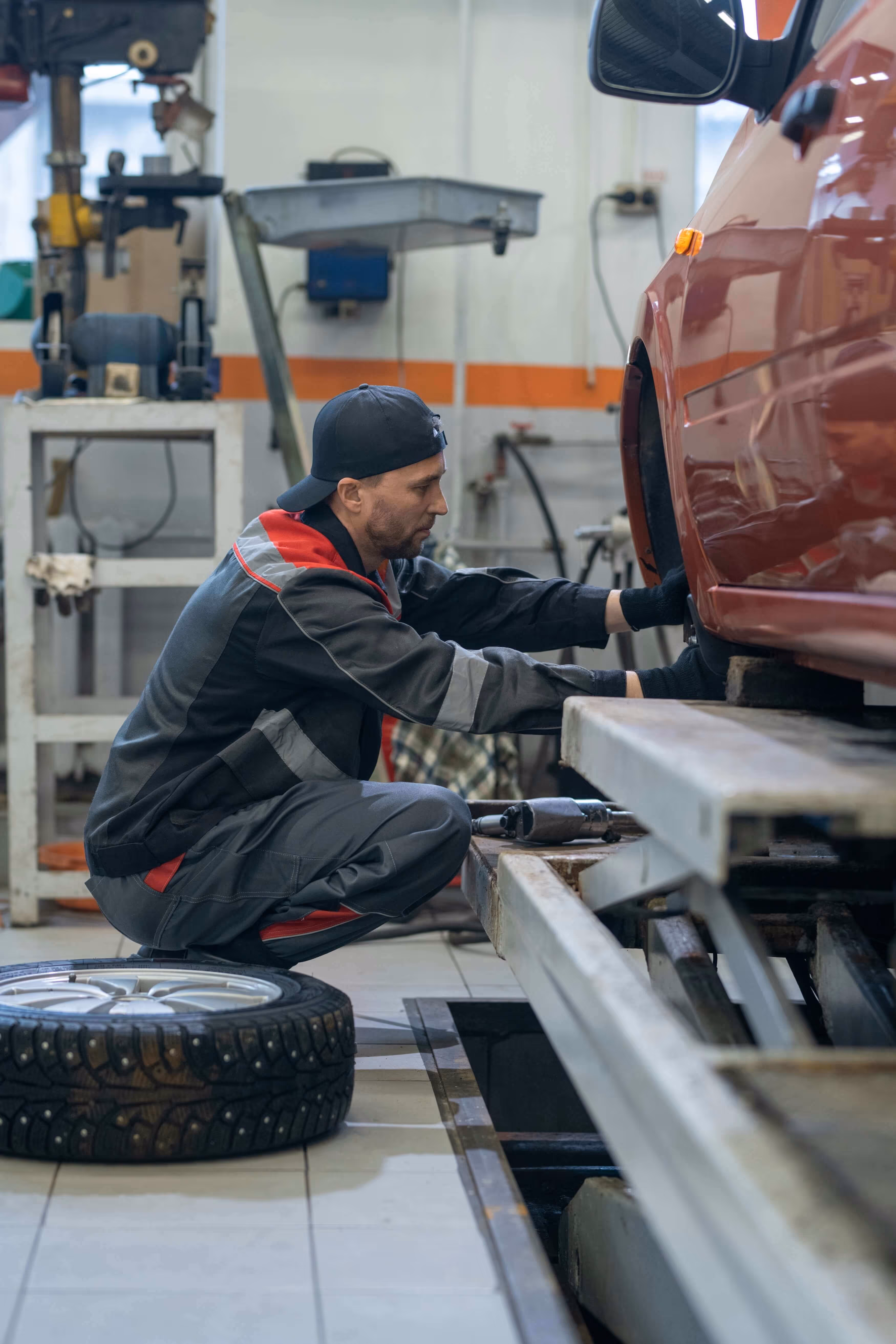 A professional mechanic working on a vehicle in a modern garage workshop, representing high-quality website design for UK MOT centres.