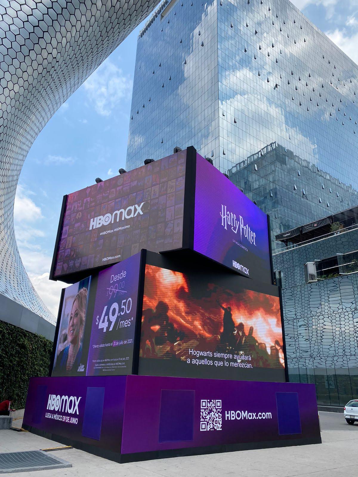 Outdoor HBO Max digital billboard promoting Harry Potter with subscription price, QR code, and reflections on buildings.