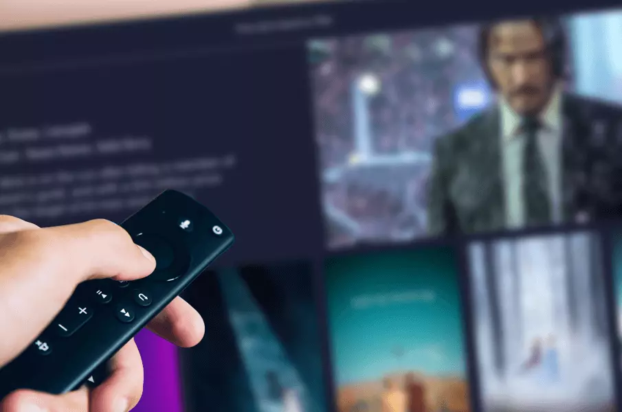 Imagen de una persona con un mando a distancia buscando películas en la televisión.