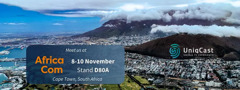 Un paisaje urbano con una cadena montañosa de fondo, un cielo nublado y un letrero que anuncia un evento el 10 de noviembre.