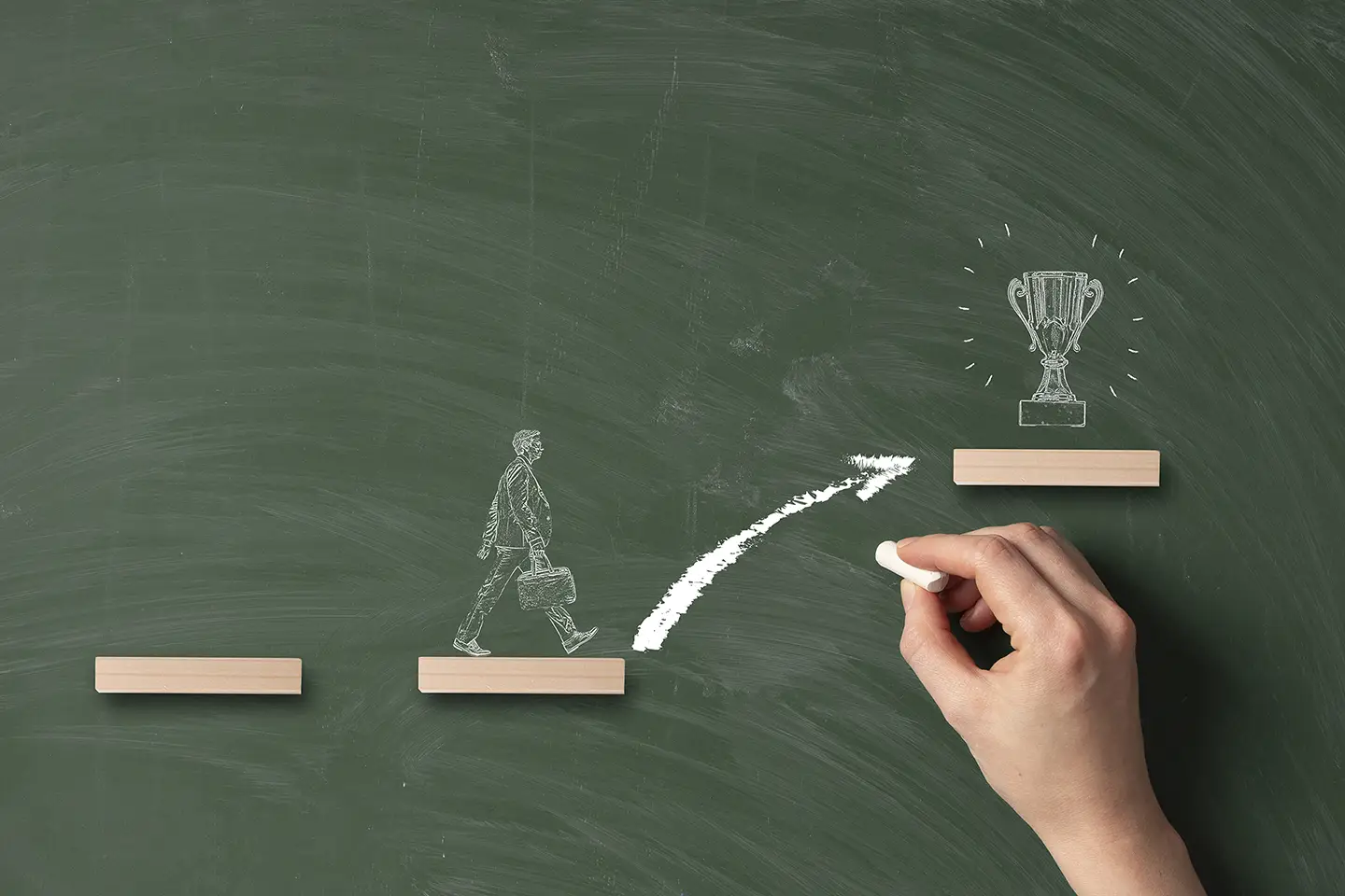 Pizarra que muestra el dibujo de un hombre de negocios que camina y necesita dar un salto hacia arriba para superar el reto y alcanzar el premio.