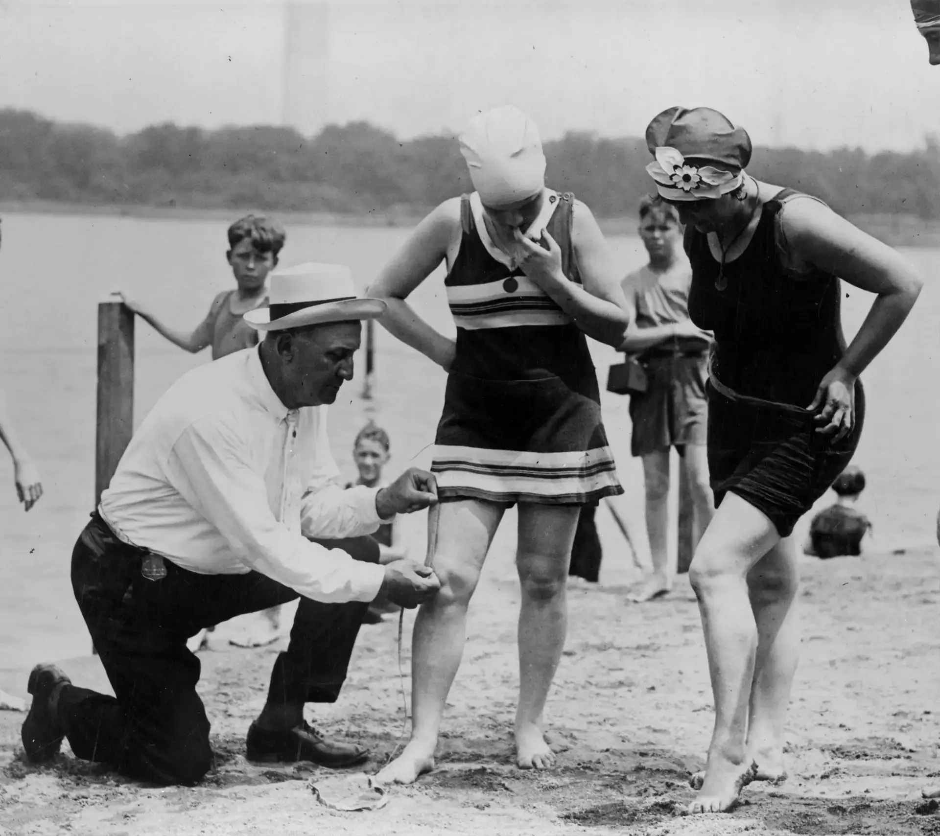 A law enforcement officer measuring skirt lengths sometime in the beginning of 1920s.