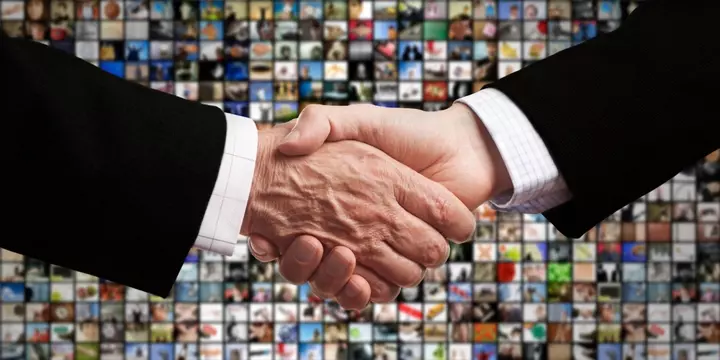 Handshake in front of wall of video streaming services