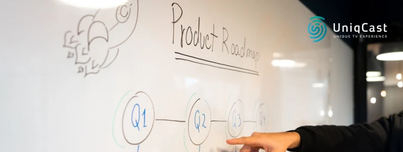 Una persona señala una pizarra blanca con una hoja de ruta del producto dibujada en ella.