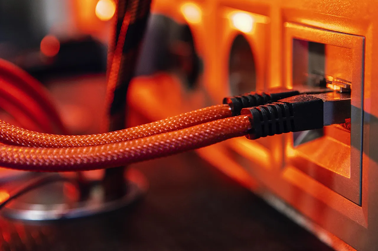 Un cable Ethernet naranja está conectado a un dispositivo.