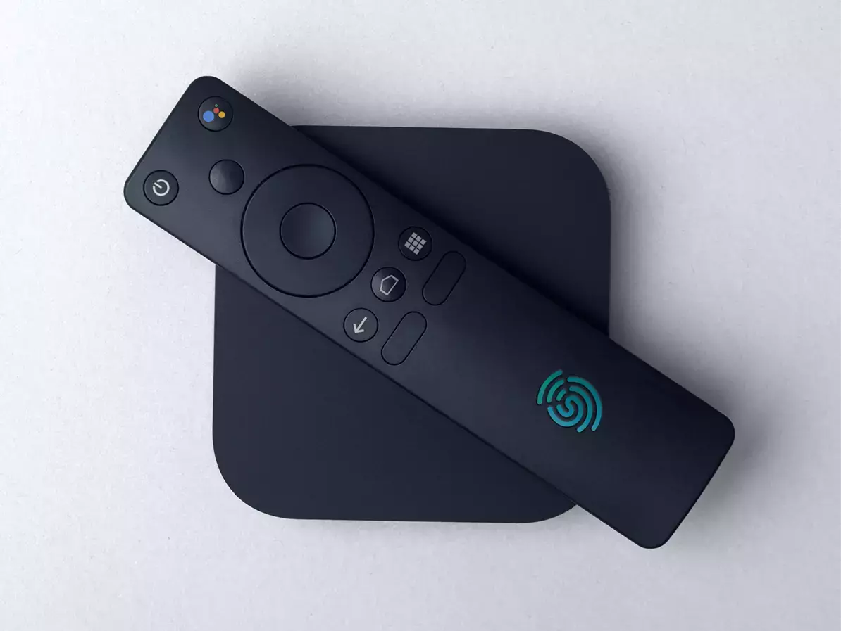 Imagen que muestra un STB negro con un mando a distancia negro, donde el mando a distancia tiene un logotipo UniqCast azul claro.