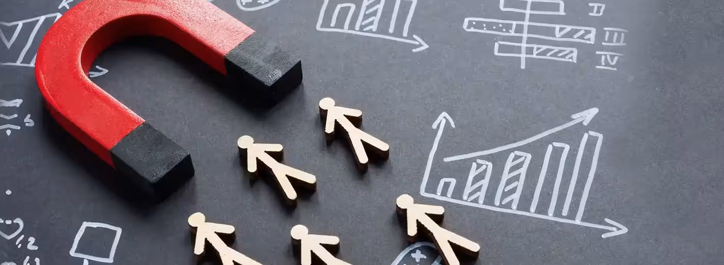 Una pizarra con el dibujo de una casa y un grupo de figuras de madera, algunas de las cuales son empujadas hacia abajo por un bloque negro.