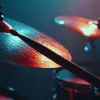 Close-up of a drumstick hitting a cymbal under stage lighting.