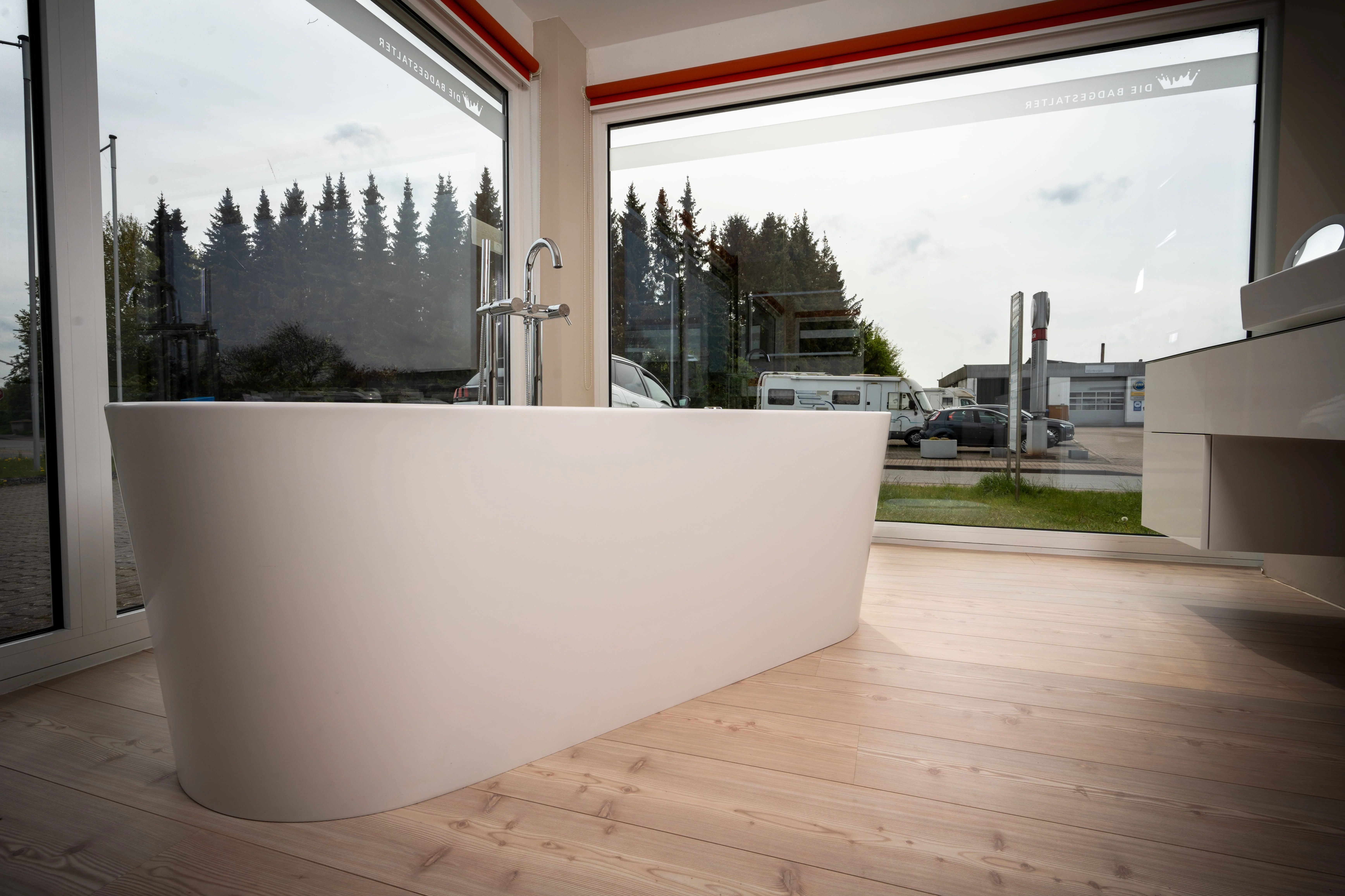 Modernes Badezimmer mit einer Dusche vor einer Wand mit vertikalen Holzpaneelen und einer grauen Sitzbank.