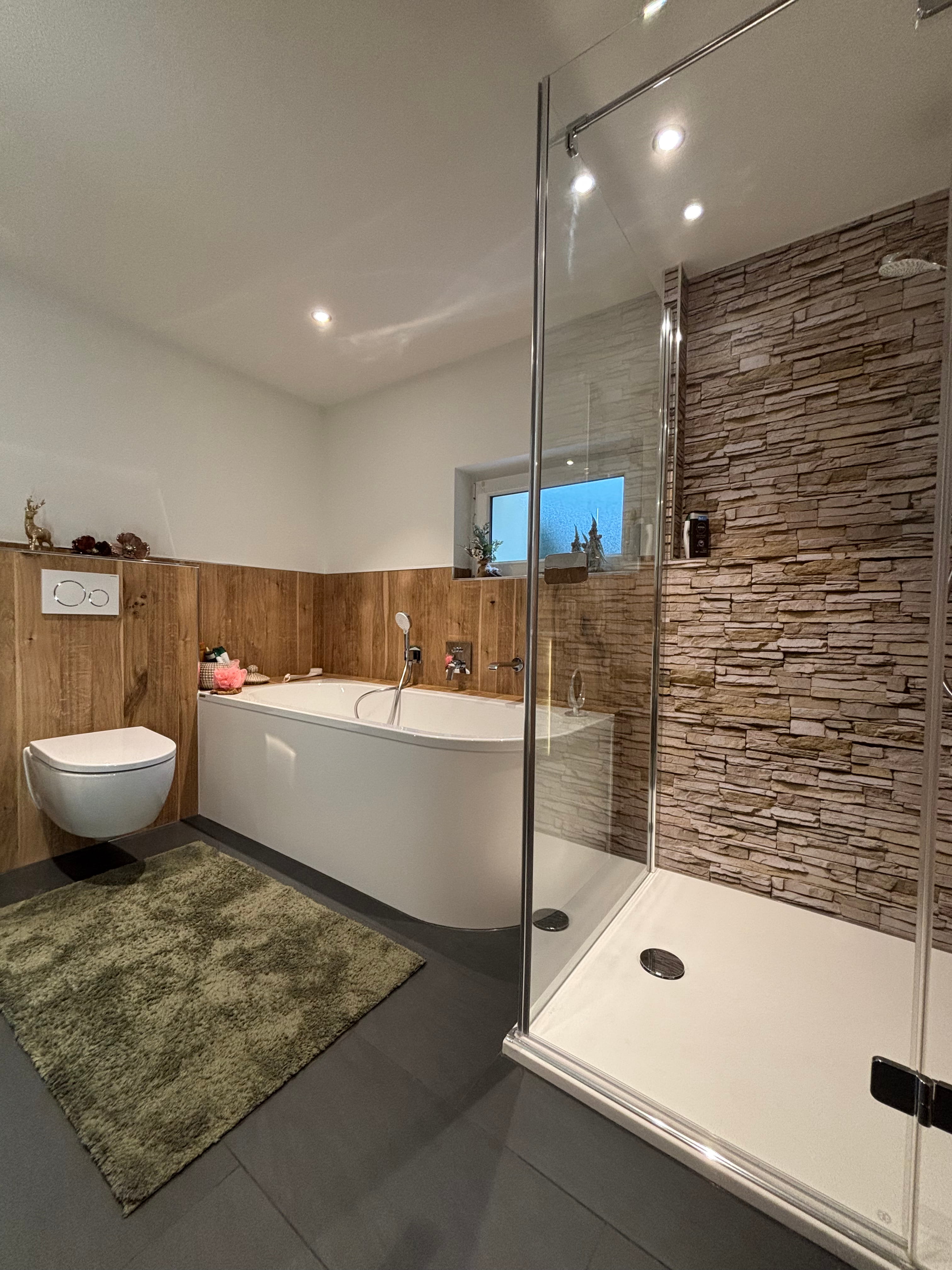 Barrierefreie Dusche mit bodengleichem Ablauf, schwarzer Regendusche, Handbrause und eingebautem Wandfach mit Beleuchtung.