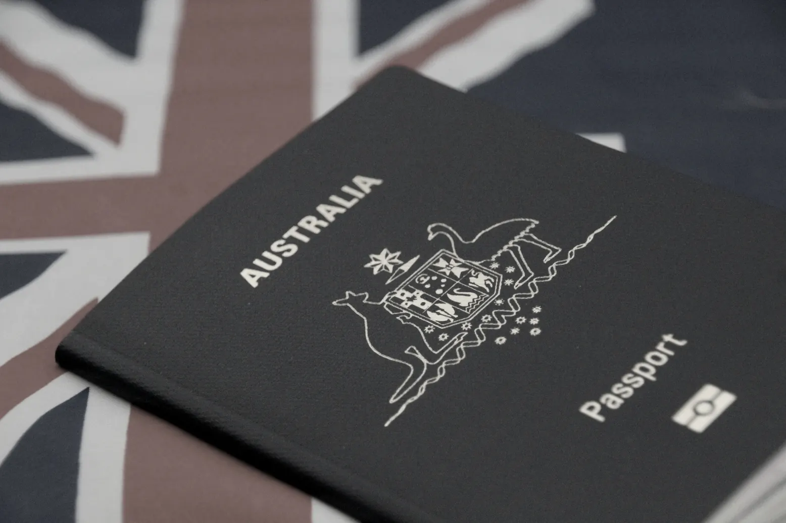 Australian passport resting on a flag, representing the E-3 visa for Australian citizens