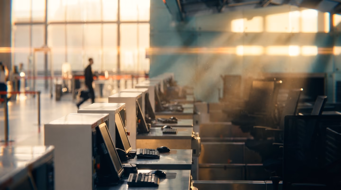 Row of empty check-in counters in an airport terminal equipped with the common use platform hardware.
