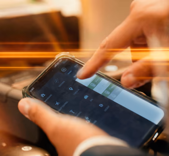 Hands holding a smartphone with finger touching the screen navigating through Ink's mobile departure control system.