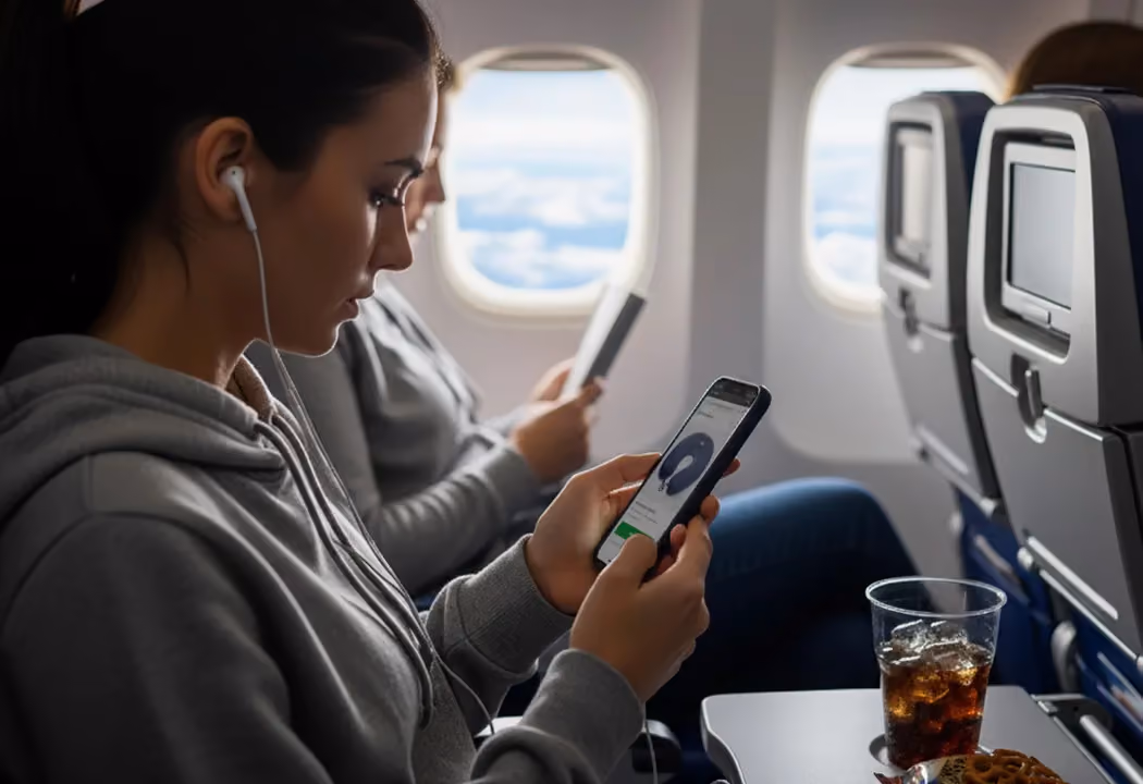 Airline passengers using smartphones, illustrating the gap between airline retailing and Amazon-style e-commerce