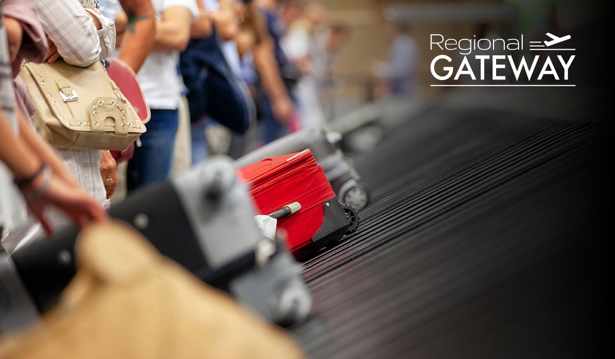 Airport baggage carousel with passengers collecting luggage