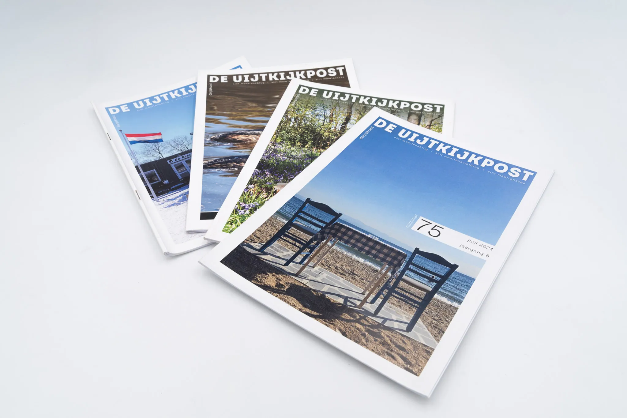 Foto van verschillende edities van Dorpskrant De Uijtkijkpost.