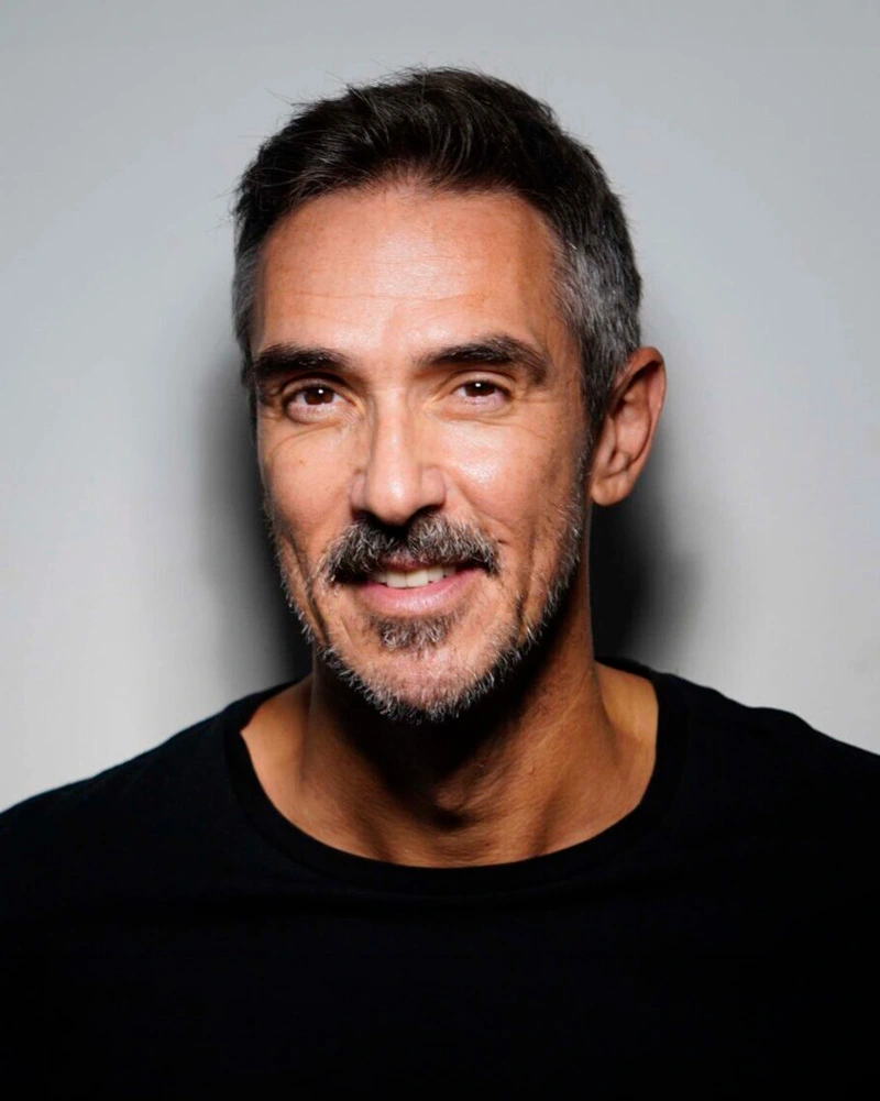 Miguel Stanley portrait - smiling in a black shirt