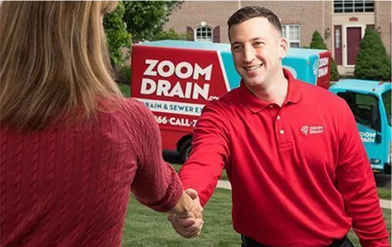 Zoom Drain employee shaking hands with a homeowner outside.