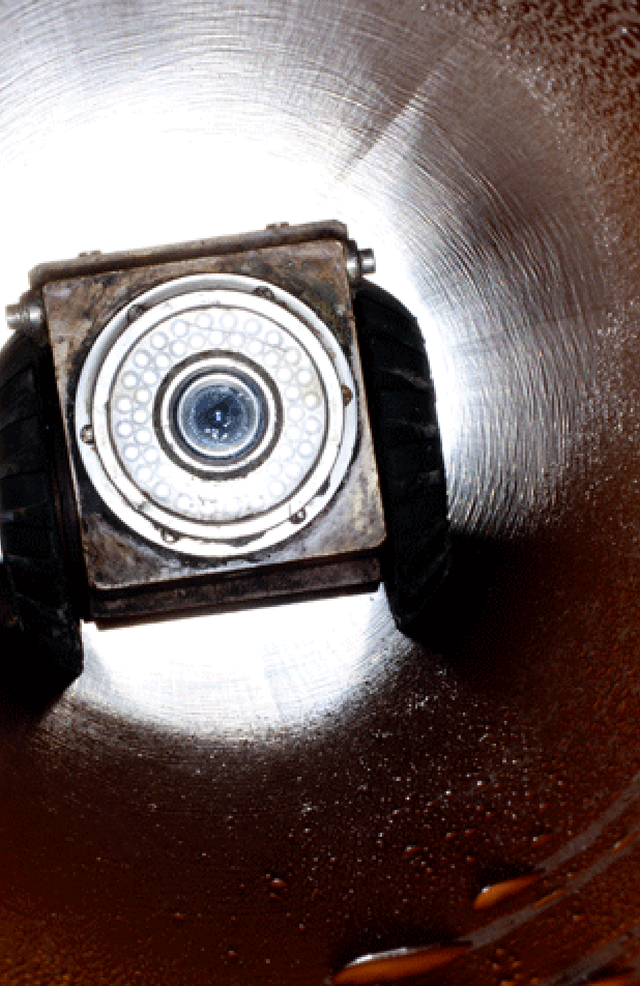 Close-up view of a sewer inspection camera inside a pipe.