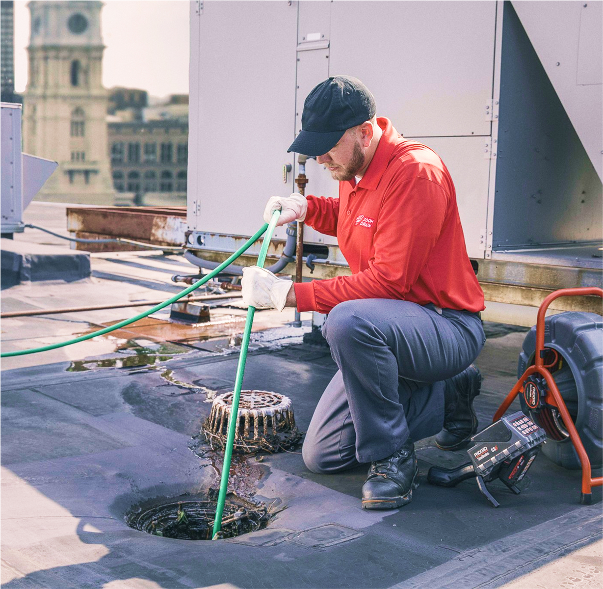Technician cleaning a residential drain using a large hose.