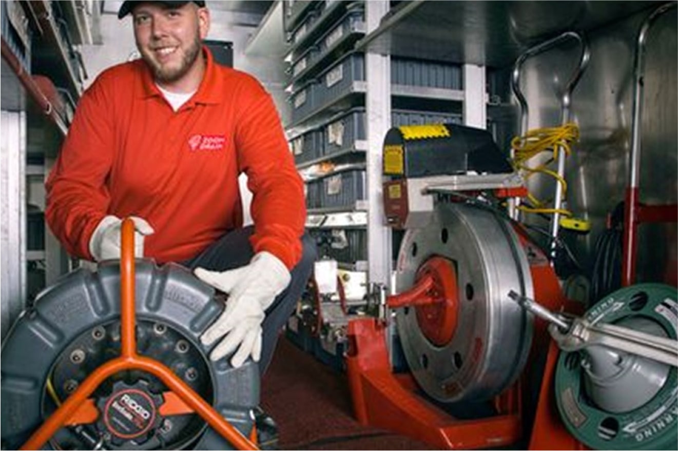 Technician using a mechanical drain cleaning machine.