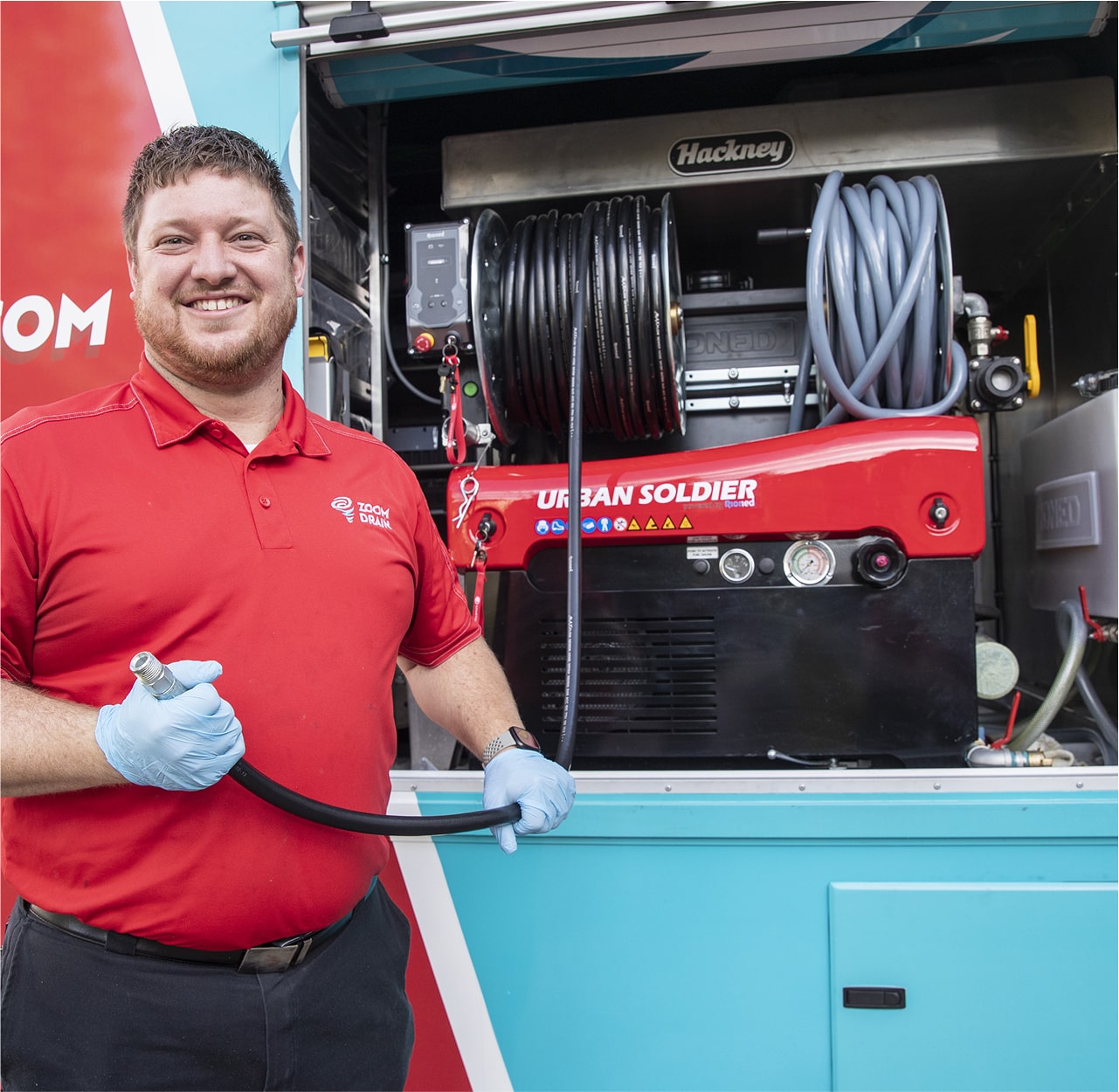 Zoom Drain technician standing beside a truck with hydro jetting equipment.