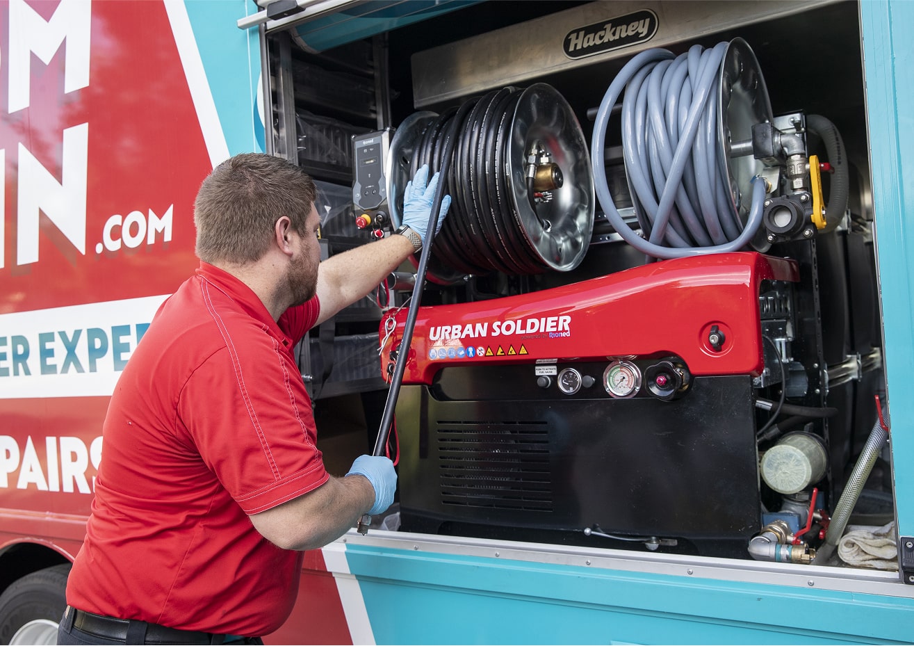 Zoom Drain technician operating drain cleaning equipment from a service truck.
