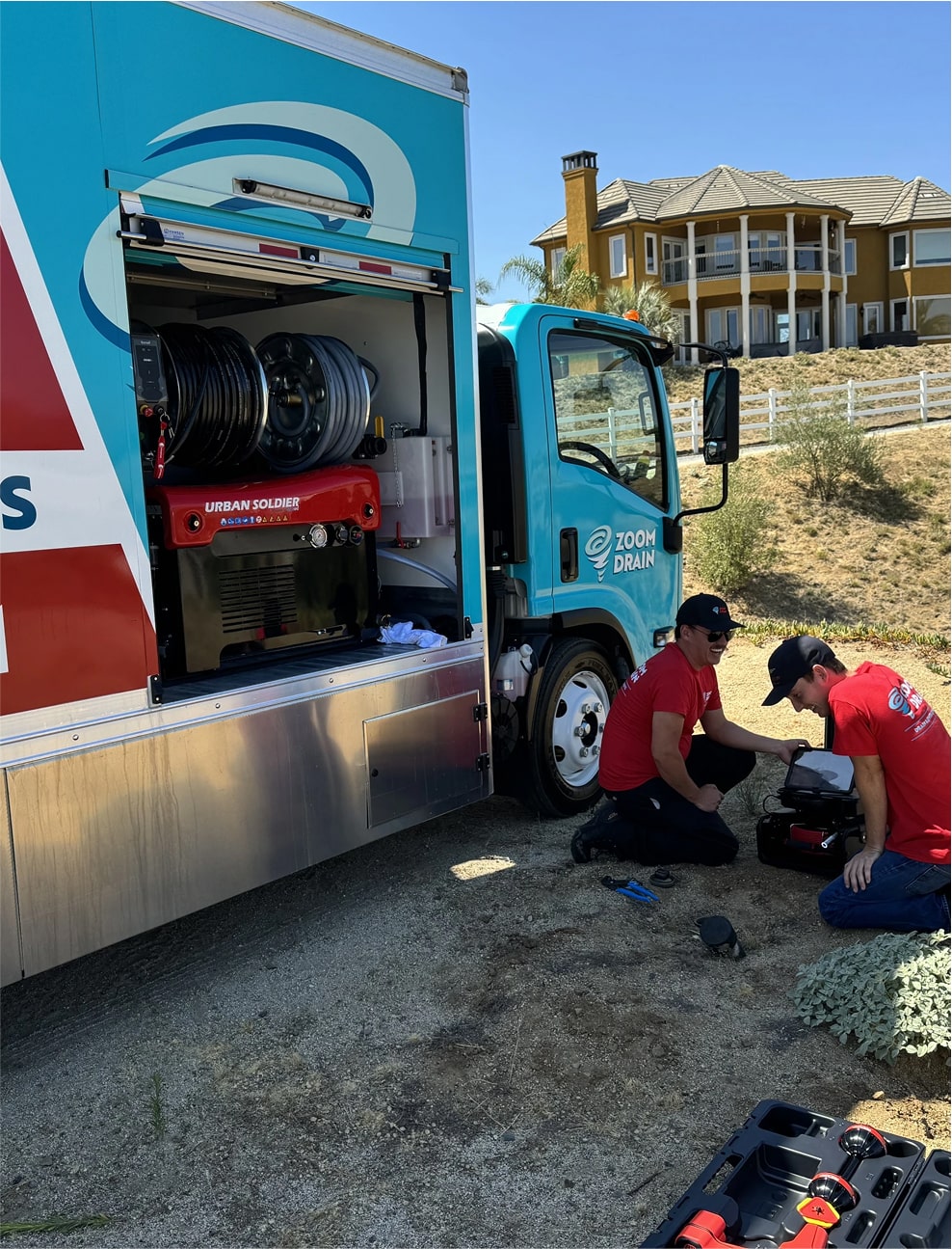 Technician operating a high-pressure jetting hose from a service truck.