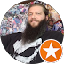 Smiling man with a beard wearing a dark shirt, orange star badge icon overlay.