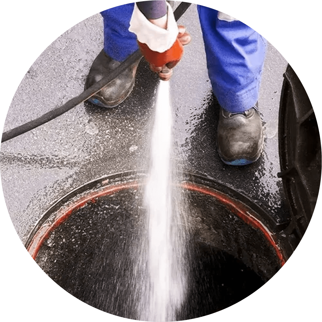 Worker using a high-pressure hose for drain cleaning.