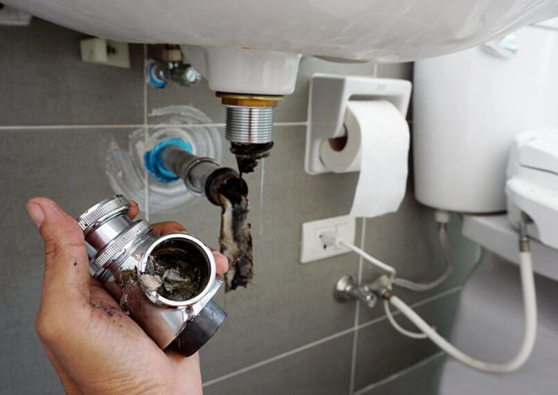 Under-sink plumbing installation showing pipes and fittings.
