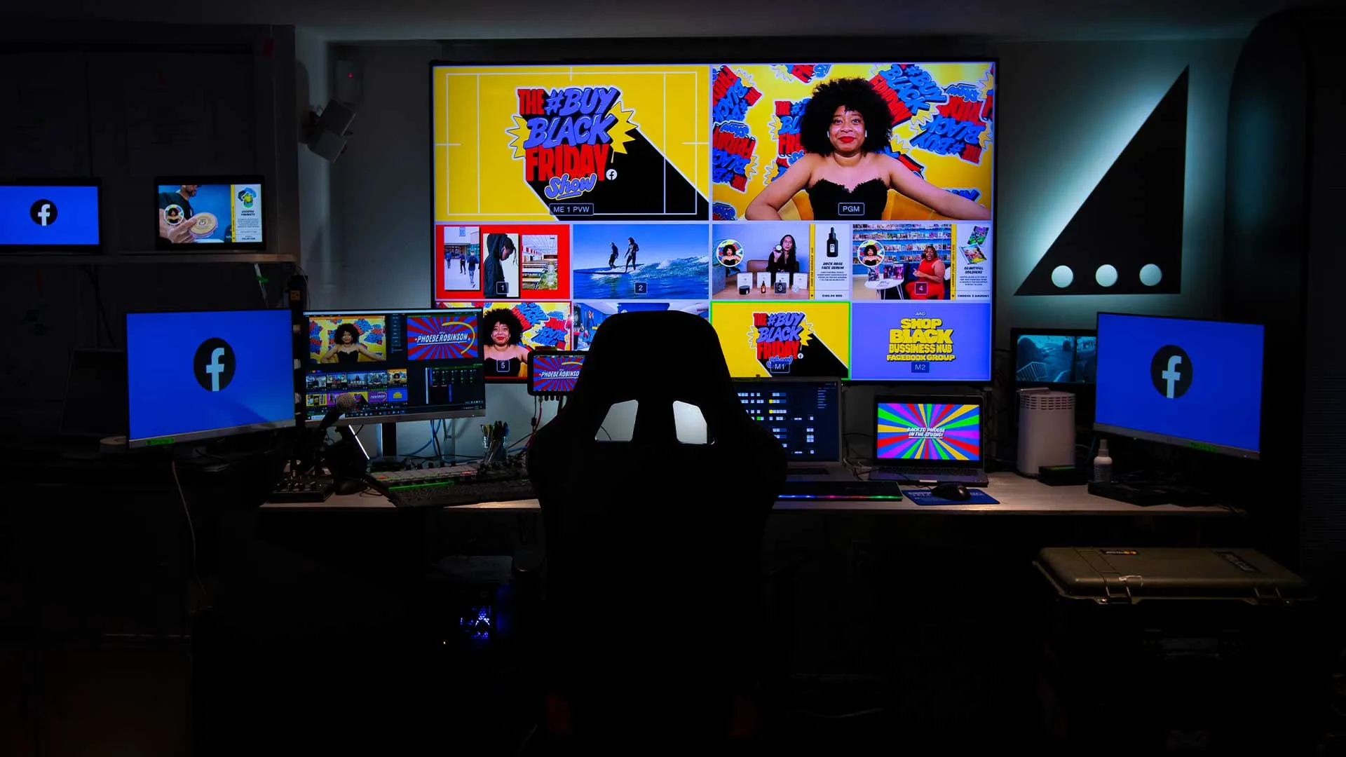 Dark control room with multiple screens showing social media content and a silhouette of a chair in front of them.