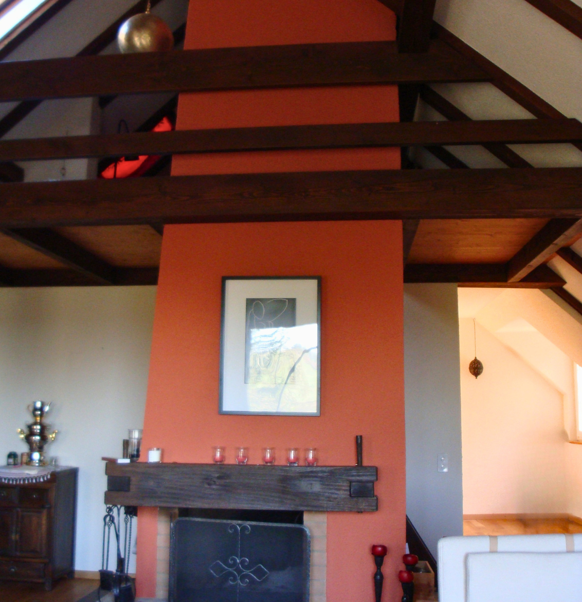 Eine grafische Fototapete mit Pflanzen, Vogel und Blumen. Davor ein grünes Sofa.