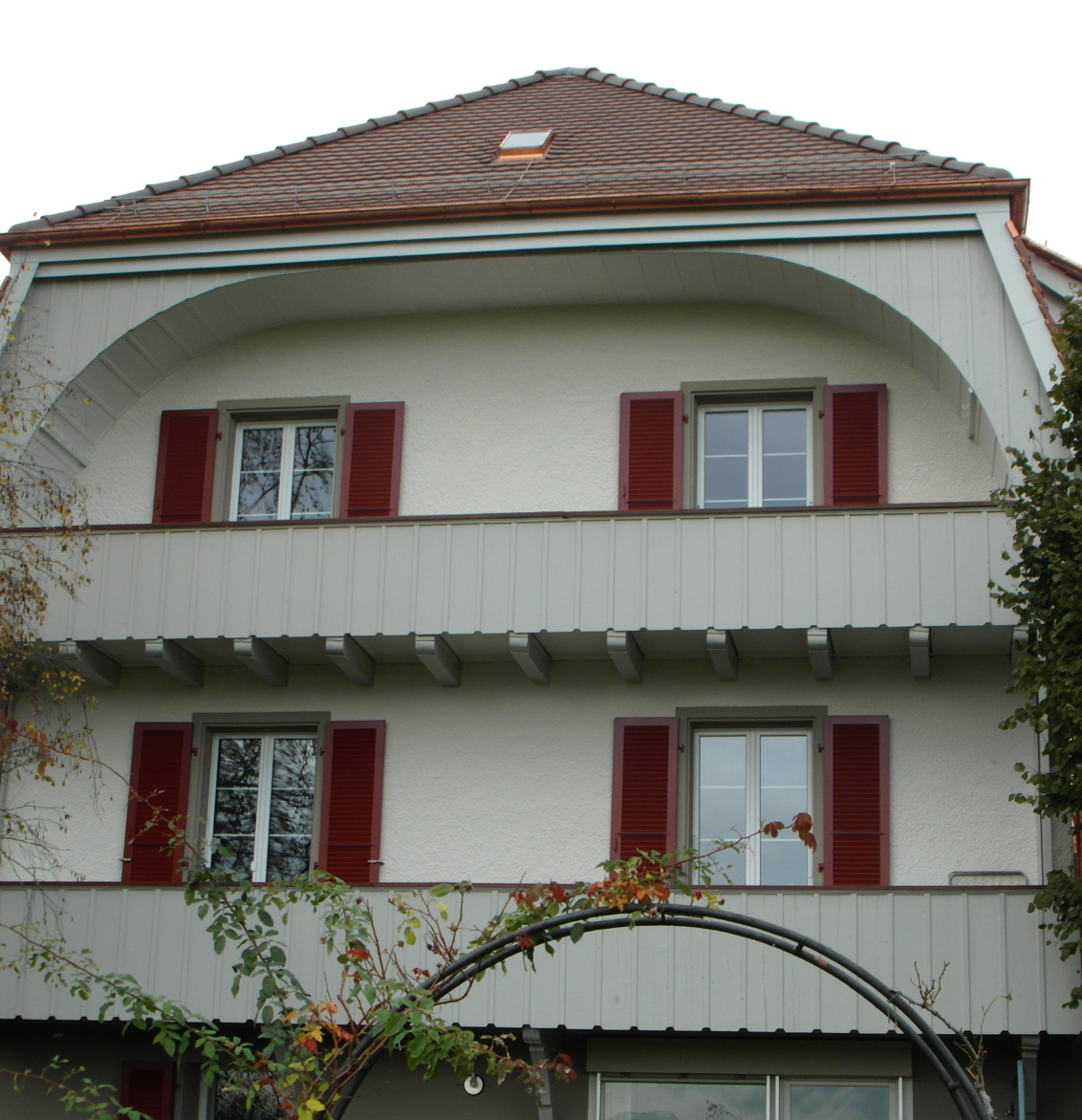 Eine grafische Fototapete mit Pflanzen, Vogel und Blumen. Davor ein grünes Sofa.