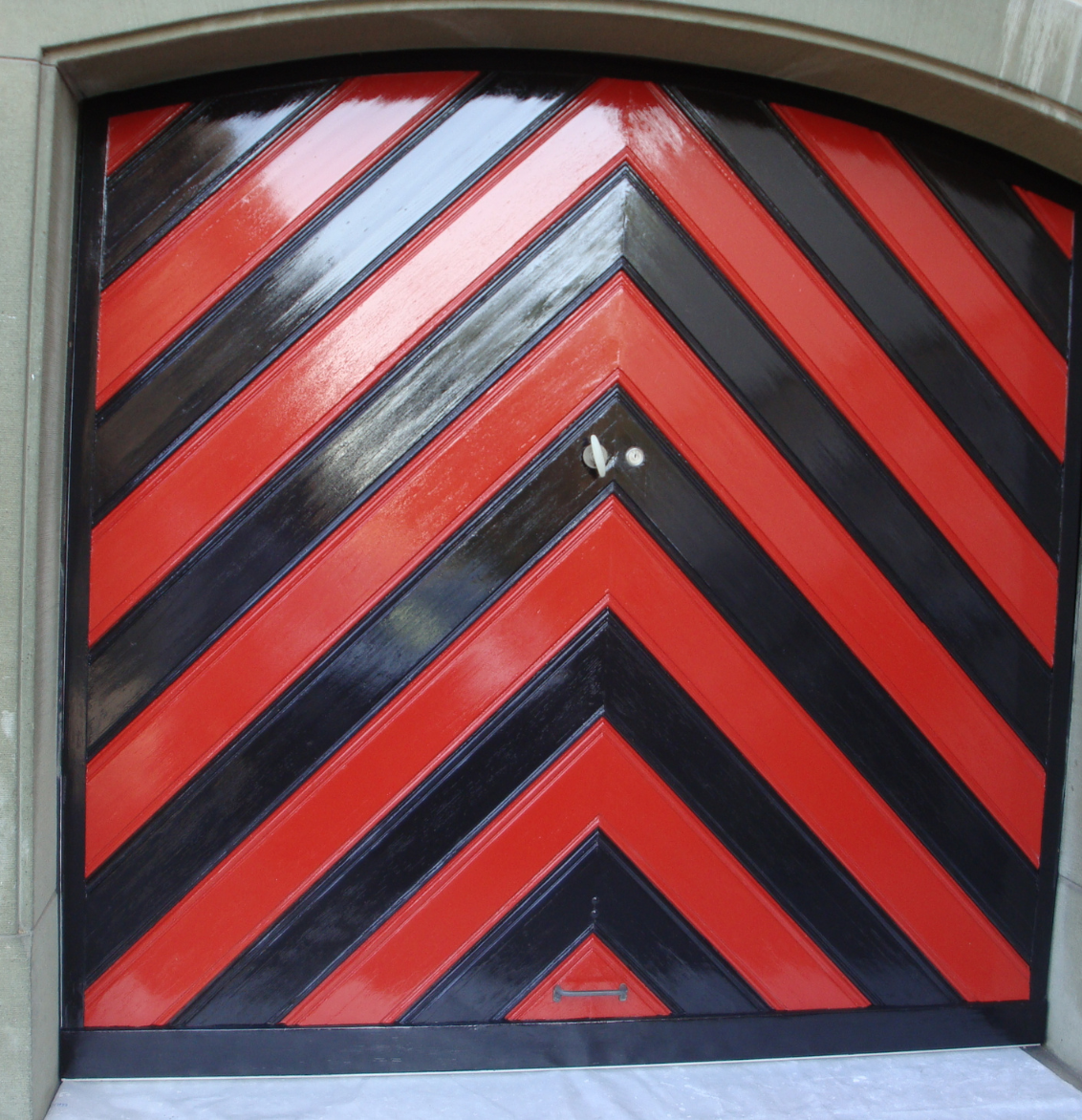 Eine grafische Fototapete mit Pflanzen, Vogel und Blumen. Davor ein grünes Sofa.