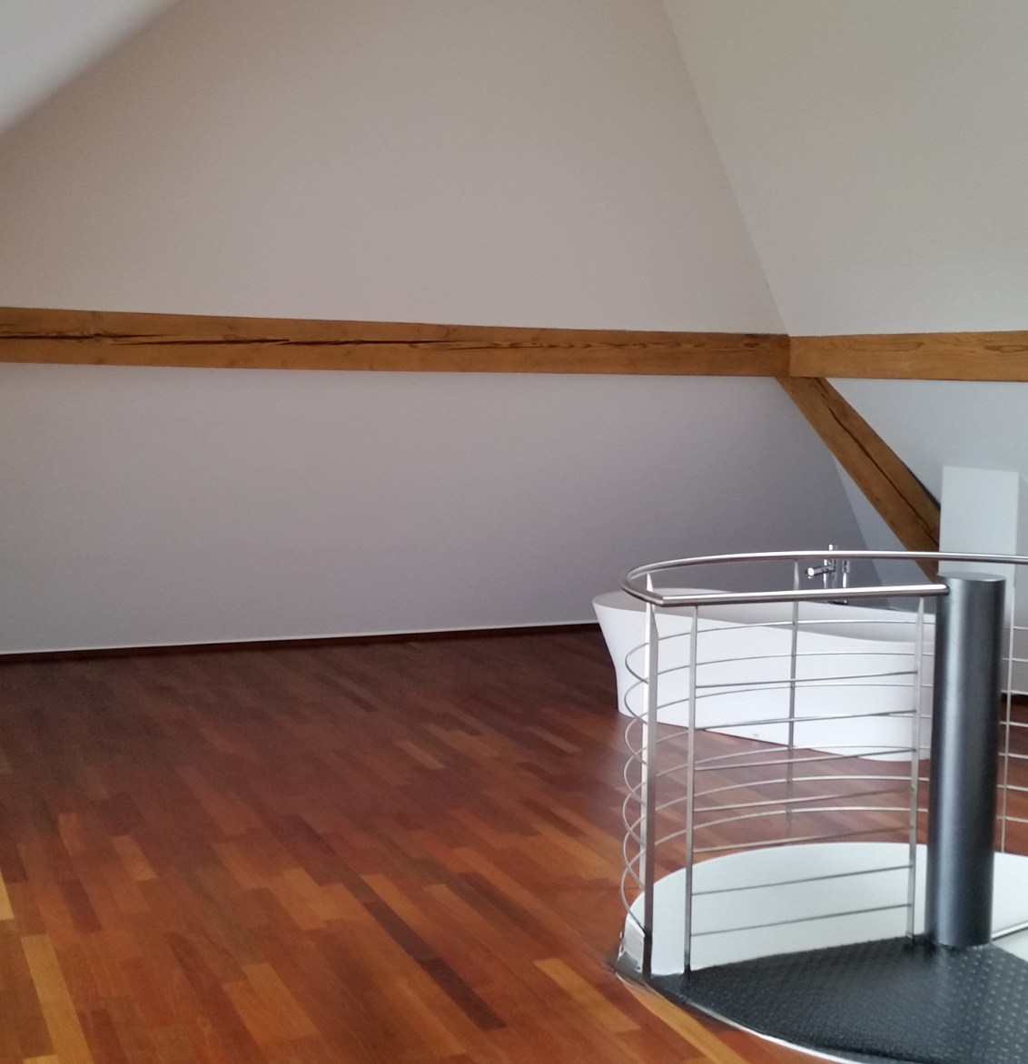 Eine grafische Fototapete mit Pflanzen, Vogel und Blumen. Davor ein grünes Sofa.