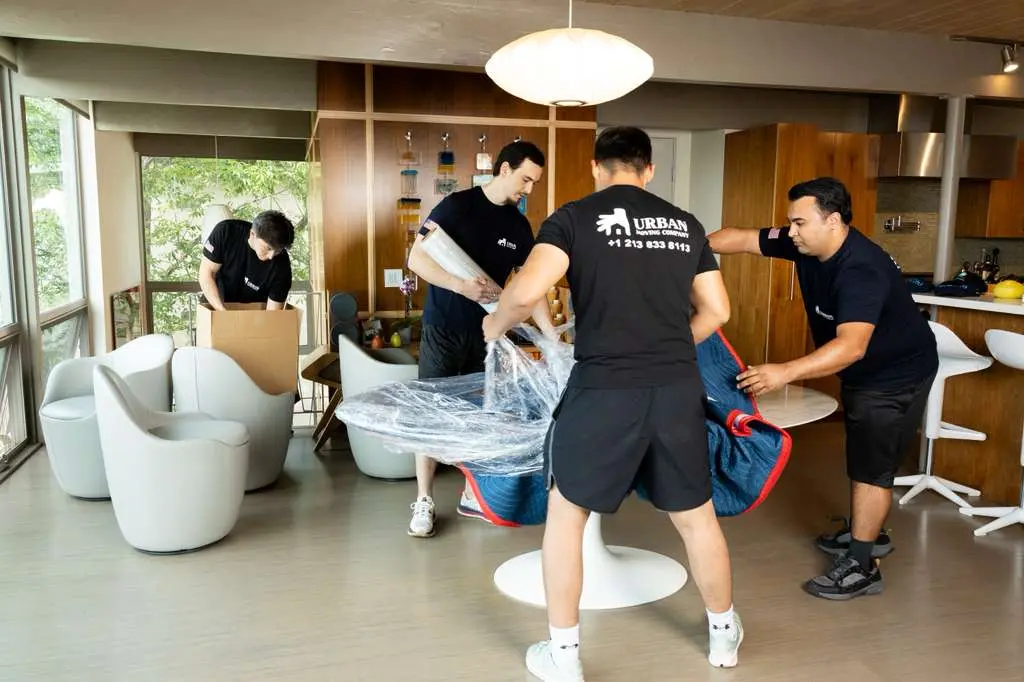 Movers wrapping furniture during residential move in Los Angeles