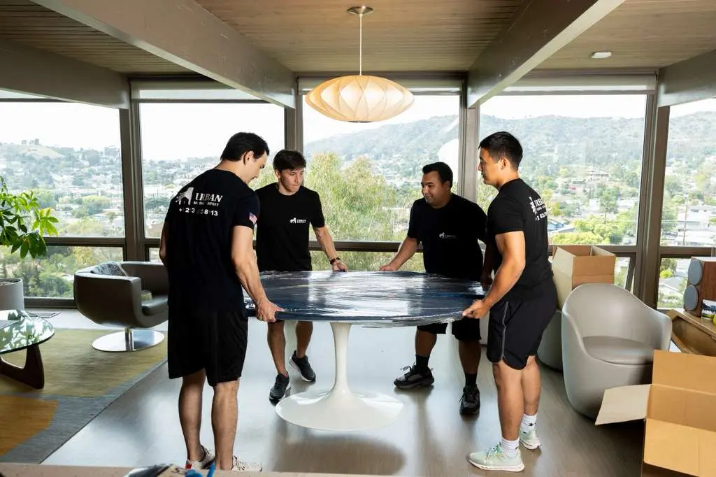 Moving team carrying furniture inside Los Angeles home