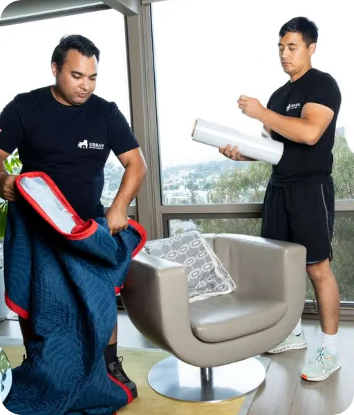 Professional movers wrapping furniture for safe transport