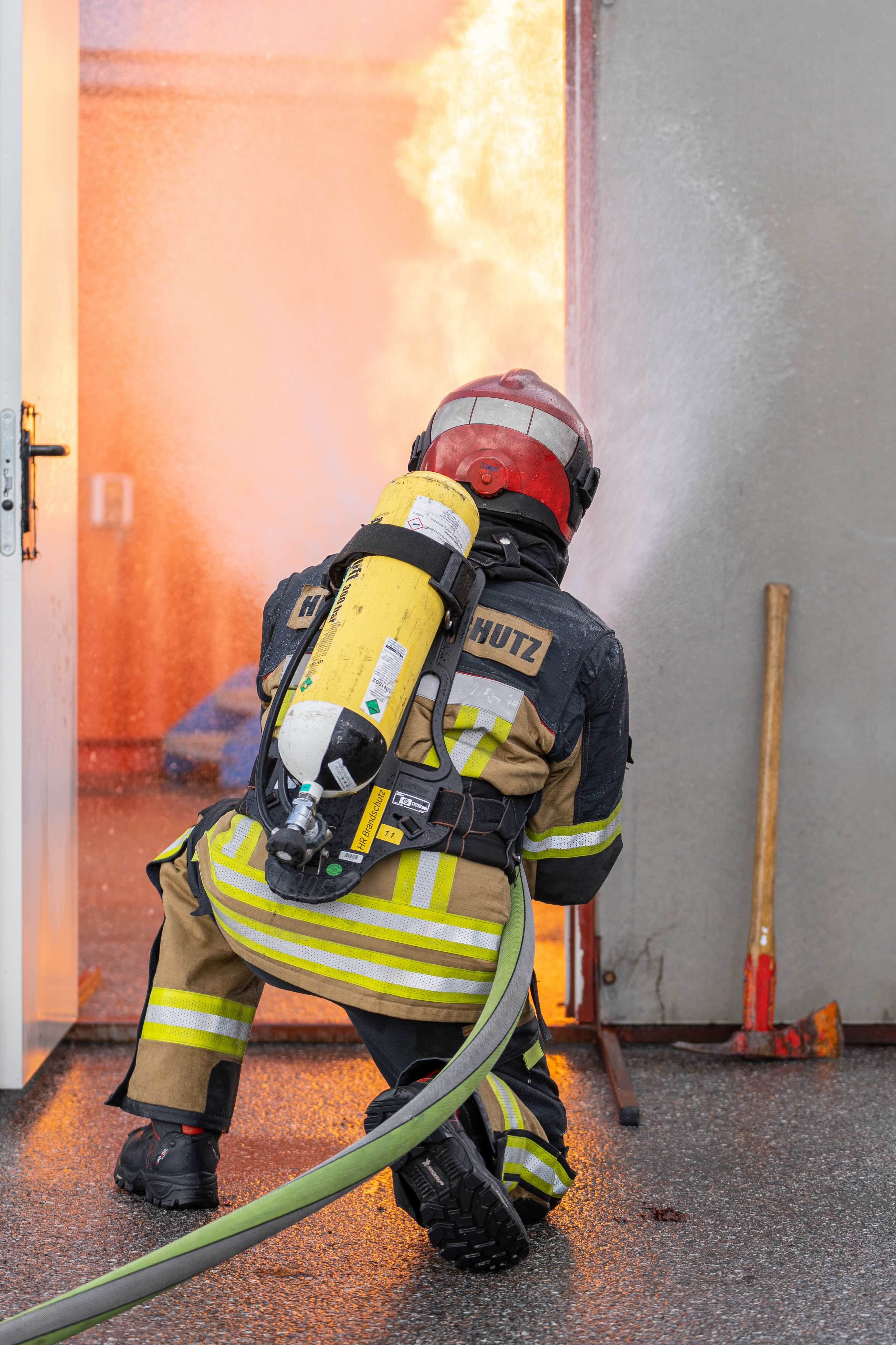 Brandschutzübung mit Feuerwehrleuten in Einsatzkleidung
