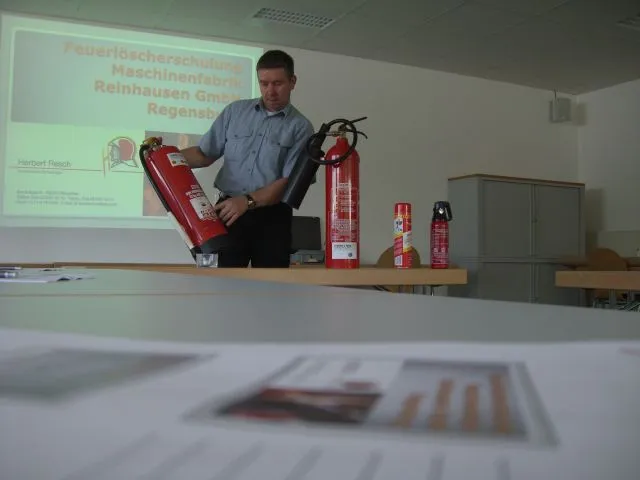 Referent präsentiert Feuerlöscher bei einer Brandschutz-Schulung