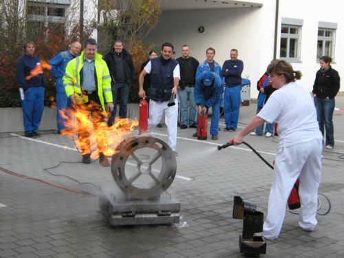 Teilnehmer löscht bei einer Übung einen Brand mit dem Feuerlöscher