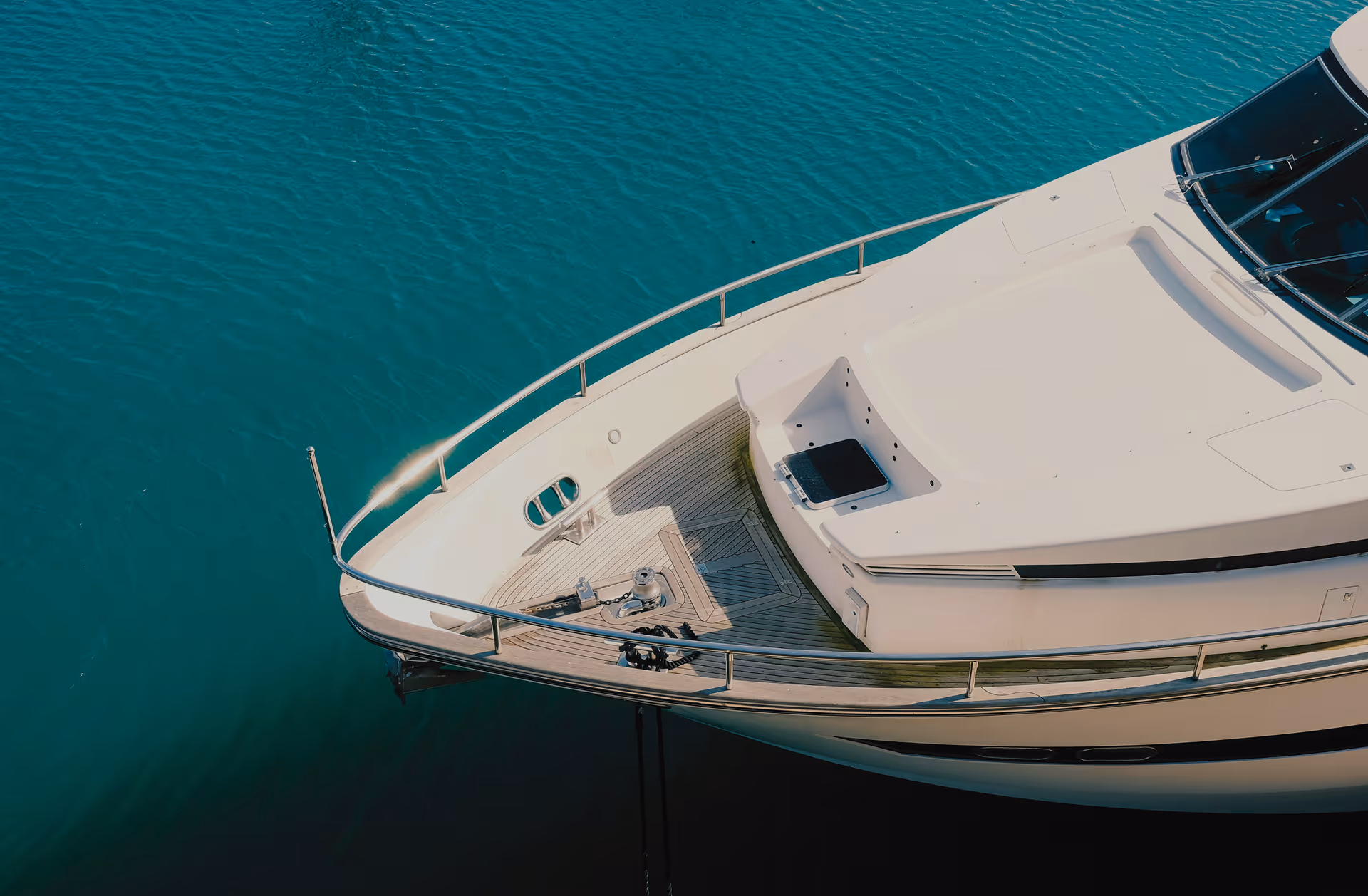 Front section of a Moveolux private rental boat floating on clear blue water.