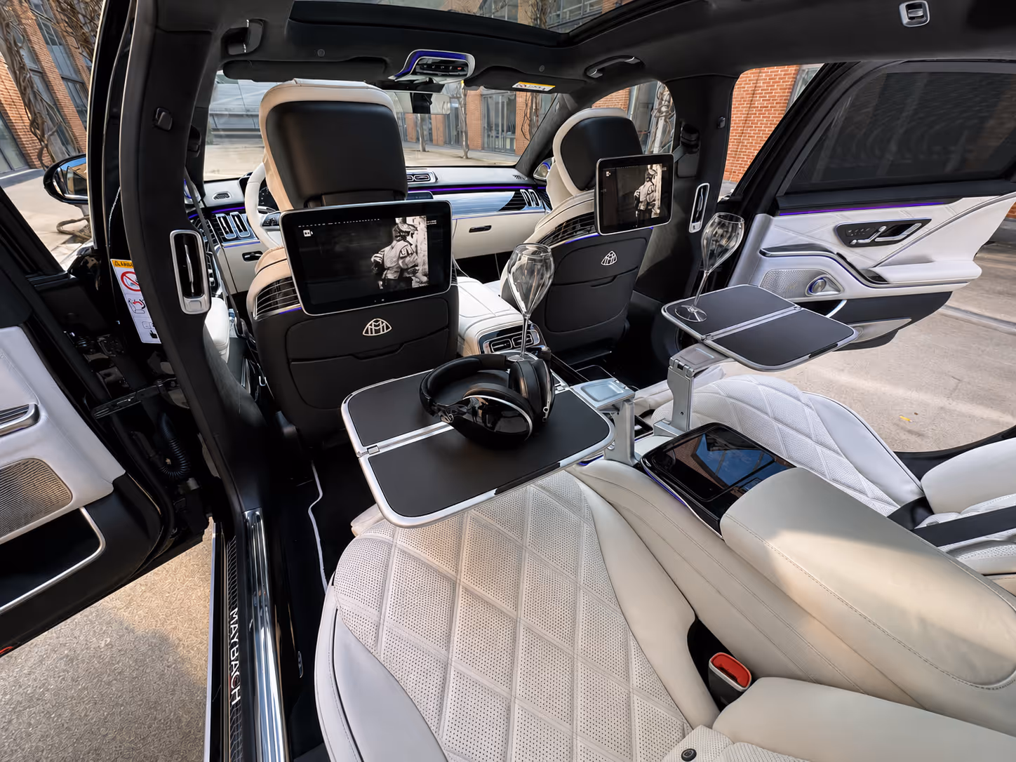 Luxurious Maybach interior with white leather seats and amenities — Moveolux white-label chauffeur service calibrated to five-star hotel standards.